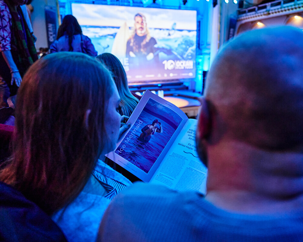 Eine Frau und ein Mann blättern in dem OCEAN Magazin