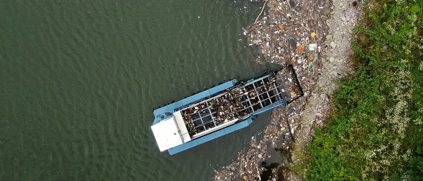Ein Cleanup Boot reinigt einen mit Müll beladenen Strand